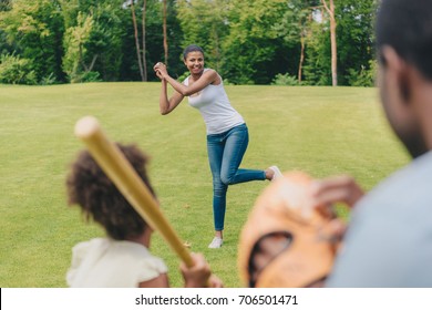 Selective Focus Of African American Woman Throwing Ball While Playing Baseball With Family