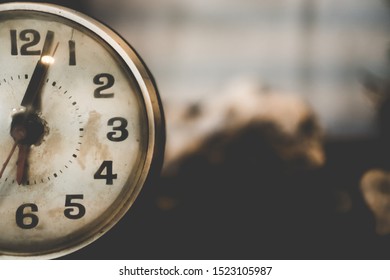 Selective Focus Of Alarm Clock On Side Table Beside Bed Show 6 O'clock In The Morning Background.Time In Life Early Bird Person Productive Concept.