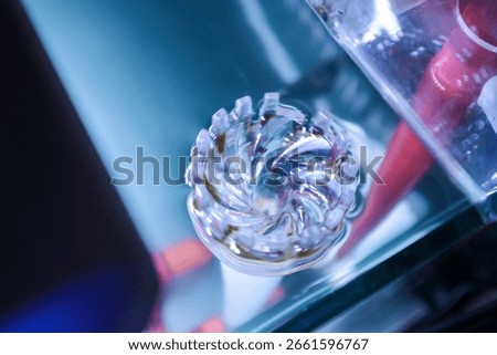 Selective focus of an aquarium surface skimmer submerged in water. The transparent plastic device removes debris and organic film from the water surface, keeping the aquarium clean and clear.