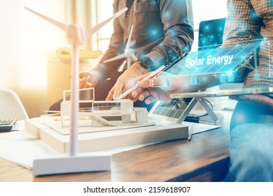 Selective focus. Architect team planning design apply renewable or solar energy on architectural building model with virtual reality technology hologram. Alternative green energy in future concept.