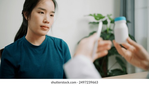 Selective focus, Asian doctor explaining how to take medicine to young female patient in clinic office, Health and medicine consultant, Conversation about healthcare