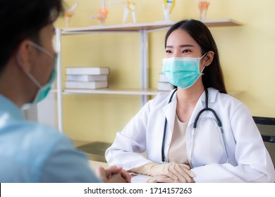 Selective Focus. Asian Doctors Wearing Surgical Masks. Wearing Doctor Gown Protective Suit And Stethoscope Consulting With Patients. Blurred Image Rear View Patient Foreground
