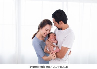 Selective focus of Asian woman and man holding newborn baby at home. Happy family smiling with adorable infant, young parents holding little sweet toddler baby, love and happiness concept. - Powered by Shutterstock