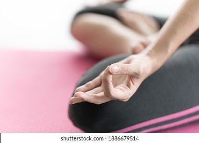 Selective Focus Of Asian Woman Sit On Yoga Exercise Mat Practicing Meditation. Clam And Relaxation Concept. White Background Copy Space. 