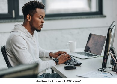 selective focus of attentive african american programmer working on computer in office