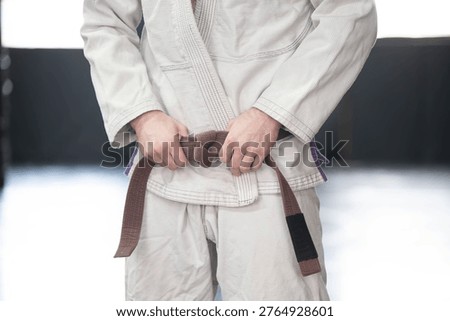 Selective focus background image martial arts kimono Gi and belt, traditional martial arts, isolated subject, copy space image, brown belt, jiujitsu martial arts rank.
