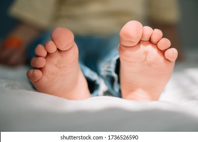 Selective Focus Of Barefoot Feet Of Cute Boy On Bedding