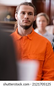 Selective Focus Of Bearded Man In Orange Jail Uniform Standing In Courtroom