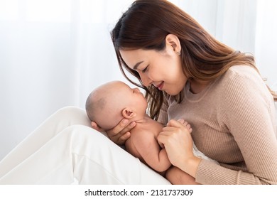 Selective Focus Beautiful Asian Mother Nose Touching Newborn Baby Nose By Her Nose With Love And Showing Protection. Mom Holding Tiny Finger Adorable Infant With Love And Care.