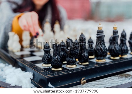 Selective focus of beautiful chess on chessboard. Close up of body part of unrecognizable woman playing in board game on street