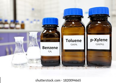 Selective focus of benzene, toluene and xylene liquid chemical compound in glass amber bottle inside a chemistry laboratory with copy space. BTX aromatic hydrocarbons used in petrochemical industry.