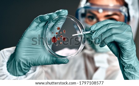 selective focus of biochemist in hazmat suit holding petri dish with biomaterial ストックフォト © 