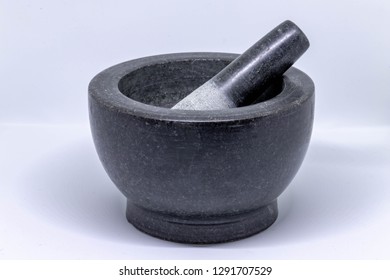 Selective focus of black marble or granite mortar and pestle on white background, Cooking tools in the kitchen, Provide a very hard base for grinding spices, seeds and nuts. - Powered by Shutterstock