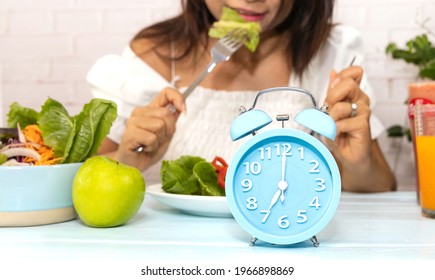 Selective Focus Of Blue Clock  And Woman Intermittent Fasting Eating Salad  Of Healthy Food Concept Image