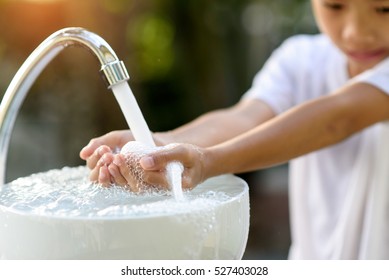 Selective Focus And Brand New Faucet And Kid Hand Taking Water.