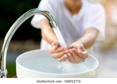 Selective Focus And Brand New Faucet And Kid Hand Taking Water.