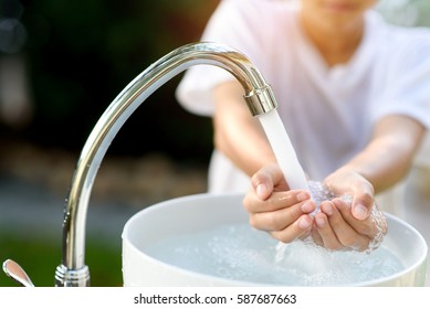 Selective Focus And Brand New Faucet And Kid Hand Taking Water.