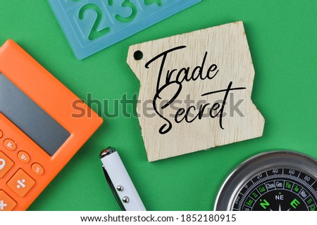 Selective focus of calculator, alphabet shape, pen, compass and board written with text TRADE SECRET. Business concept.