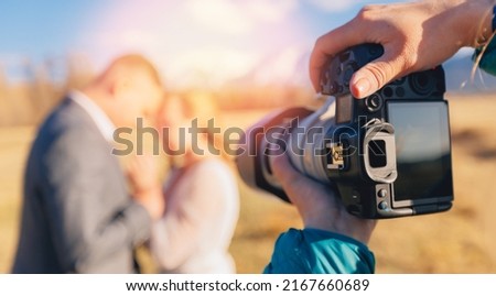 Selective focus camera of wedding photographer in action lover couple.