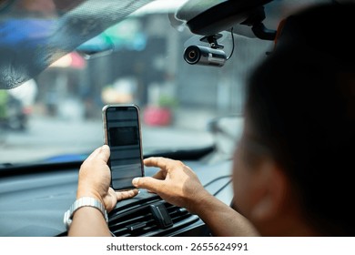 selective focus to Car CCTV camera video recorder. The technician is installing front camera car with smartphone for safety on the road.  Dashcam in car to record evidence in case of emergency.