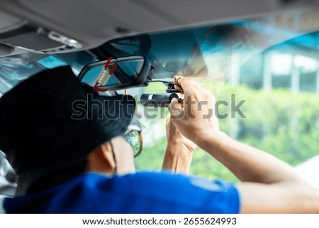 selective focus to Car CCTV camera video recorder. The technician is installing front camera car, Car camera for safety on the road.  Dashcam in front of car to record evidence in case of emergency.