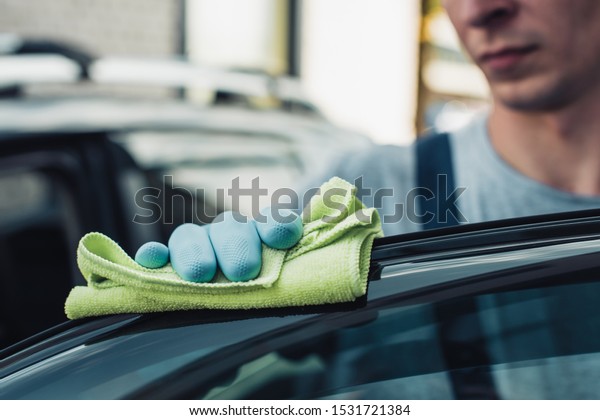 selective\
focus of car cleaner polishing car with\
rag