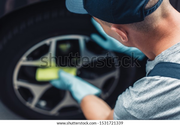 selective\
focus of car cleaner wiping wheel with\
rag