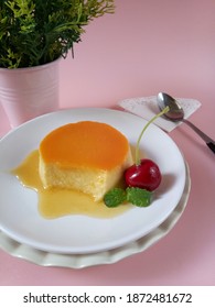 Selective Focus Of Caramel Pudding In A White Plate With Pink Background