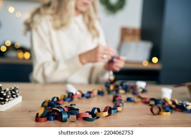 Selective Focus Of Caucasian Woman Making DIY Paper Chain For Christmas Tree 