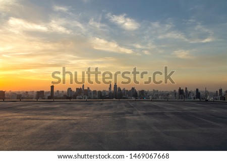 Selective focus of the cement floor with cityscape background in the evening at Bangkok , Thailand. Cement floor on the roof with sunset over the building in capital. 