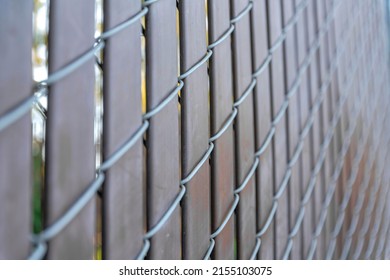 Selective focus of a chain link fence with brown privacy strips at Japanese Friendship Garden