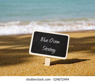 Selective focus of chalk board written with BLUE OCEAN STRATEGY text. Wave and blue ocean background. 