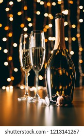 selektiver Fokus von Champagnerflasche und Gläsern auf grauem Hintergrund, Weihnachtskonzept