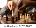 Selective focus of chess match in progress, capturing intensity of friendly game day. Close up of caucasian and african american individuals moving pieces on chessboard on table.