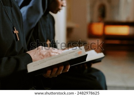 Selective focus closeup hands of two diverse nuns reading religious texts in books, copy space