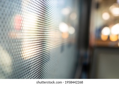 Selective focus, close-up view at One Way Vision sticker film with dot pattern on glass of Train's window and blurry background of train's passenger train and bokeh.