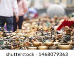 (Selective focus) Close-up view of some souvenirs (singing bowls, hand created statues and Rudraksha necklace) on a street market stall in Kathmandu Durbar Square, Kathmandu, Nepal.