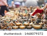 (Selective focus) Close-up view of some souvenirs (singing bowls, hand created statues and Rudraksha necklace) on a street market stall in Kathmandu Durbar Square, Kathmandu, Nepal.