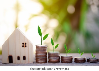 Selective focus of coins stack and plant growing with house model for saving money to buy a home, property with small house and bokeh background.  - Shutterstock ID 1789594865