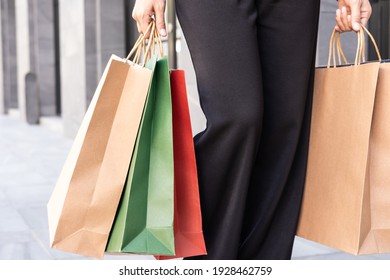 Selective Focus At Colorful Shopping Bags. Women Carry Many Shopping Back And Walking Out From Fashion Department Store. End Of Year Season Sale That Customer Have High Volume Purchase.