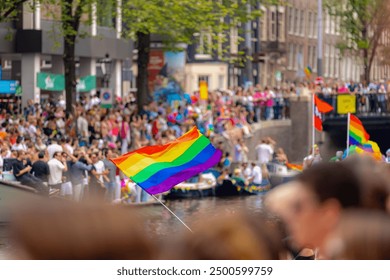 Selective focus of colourful rainbow flags along canal, Amsterdam canal parade decoration, LGBTQ community, Annual festival to celebrate in August, One of the greatest events in the world, Netherlands