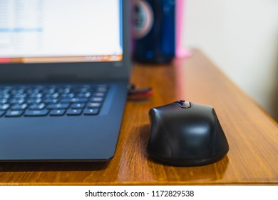 Selective focus of computer mouse beside the laptop with space for putting text