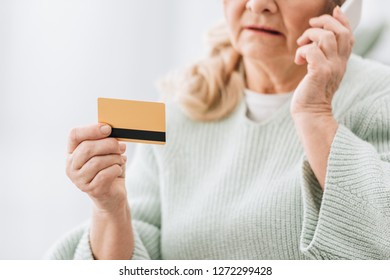 Selective Focus Of Credit Card In Hand Of Senior Woman Talking At Smartphone 