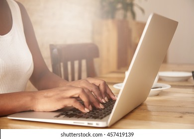 Selective Focus. Cropped Shot Of Black Woman's Hands Typing On Keyboard While Messaging Friends Via Social Networks Using Computer Laptop. Female Manager Checking E-mail, Sitting At The Wooden Table