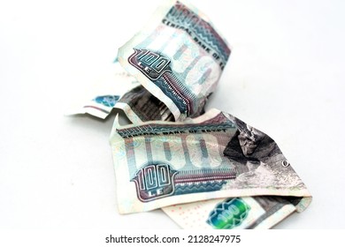 Selective focus of crumpled Egyptian money of 100 LE one hundred pounds isolated on white background, wrinkled 100 pounds cash bill banknote, economy inflation concept