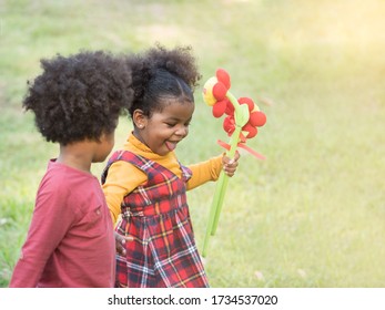 Selective Focus, Cute Little Mix Race Toddler Girl Feeling Shy When Afro Boy Holding Hands In The Park.