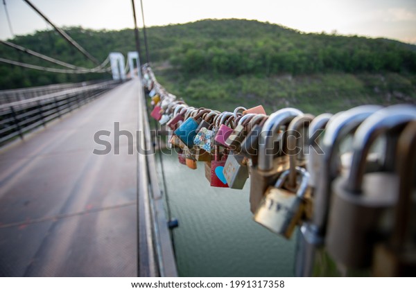 selective focus a lot of different love\
padlocks on hemp rope Locks left by people in love, a symbol of\
eternal love. Pine suspension bridge in\
Thailand.