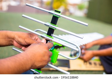 Selective Focus To The Digital TV Antenna With The Hands Of A Technician Is Installing.