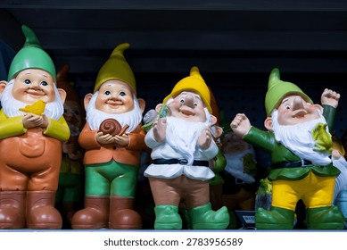 Selective focus display of rows of cute jolly decorative garden gnomes on shelf in store