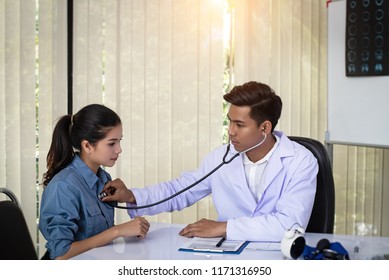 In Selective Focus Of The Doctor Is Using The Stethoscope For Check Heart Rate Of The Patient,at Hospital,warm Light Tone,blurry Light Around